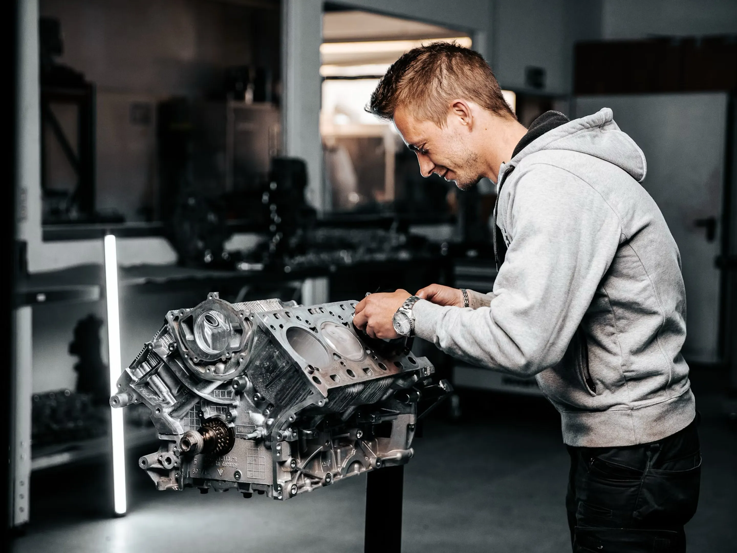 Auszubildender arbeitet an einem zerlegten Motorblock in der Werkstatt von MIK Motoren
